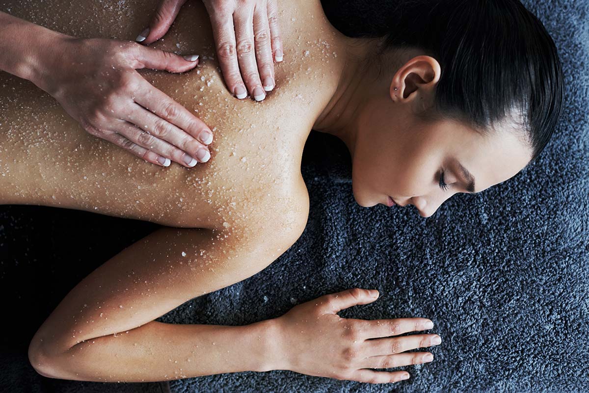 Shot of a young woman getting a back scrub at a spa